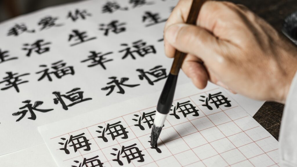 high angle man writing chinese symbols white paper